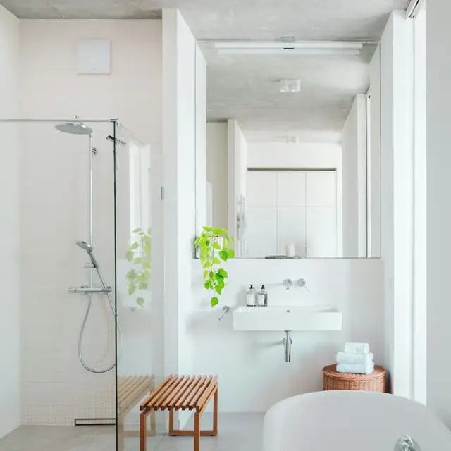 El baño después de la limpieza: ducha abierta, banco de madera y bañera