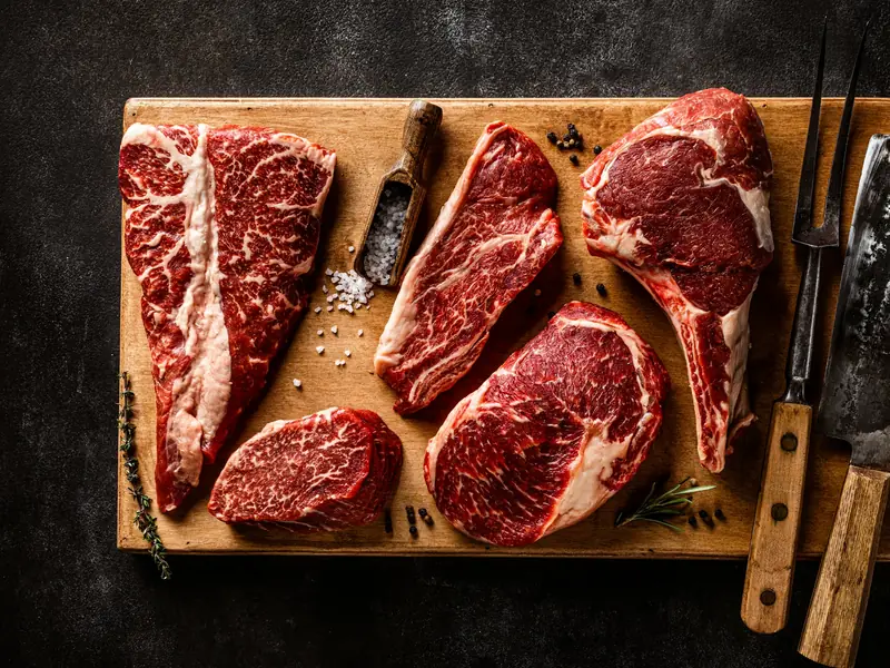 Raw beef cuts laid out on a butcher’s board