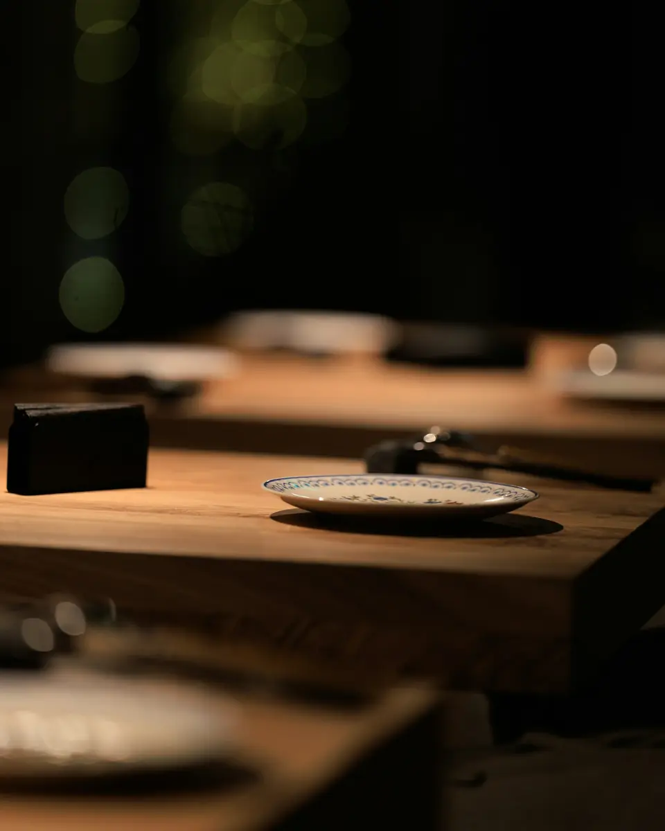 Mesas de madera montadas para la cena en una sala en penumbra