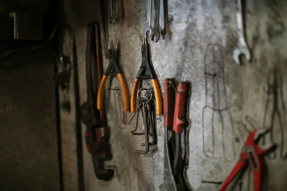 Pliers and wrenches hanging on the workshop wall