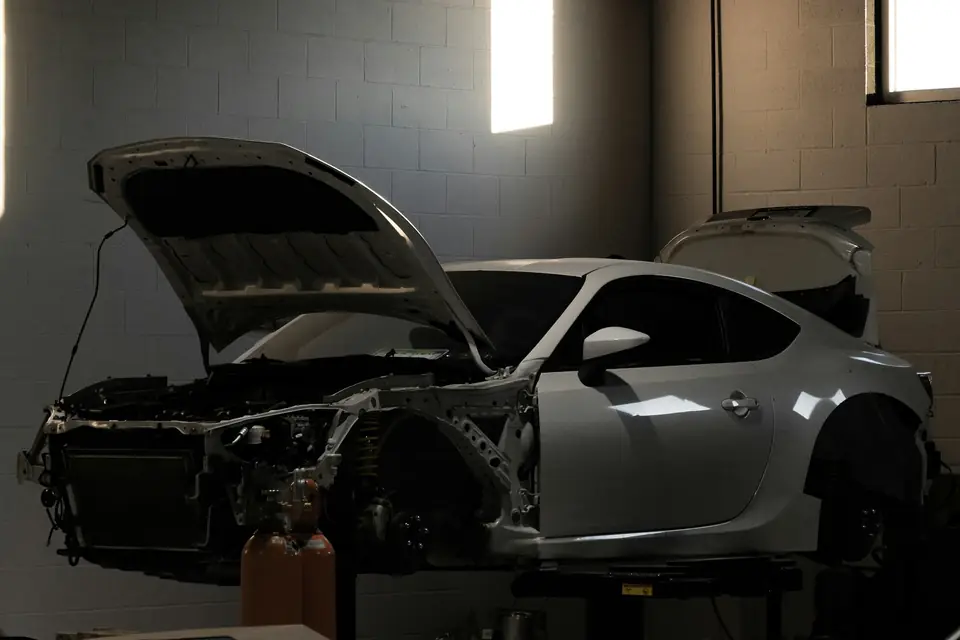 A coupe stripped for repair under the workshop windows